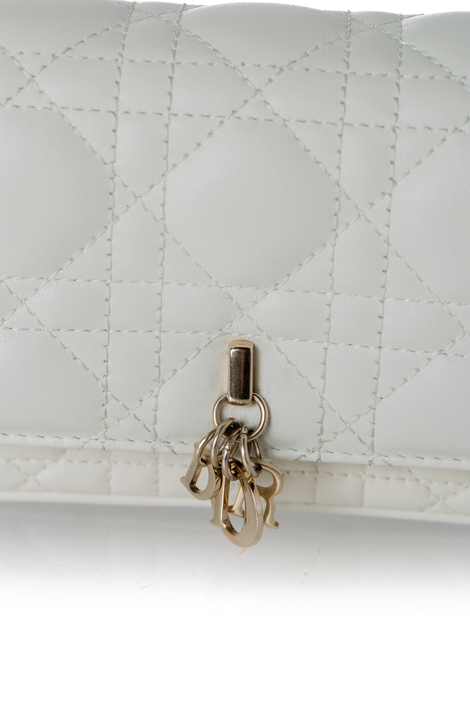 Detalle charms D.I.O.R. dorados sobre Cannage latte Christian Dior