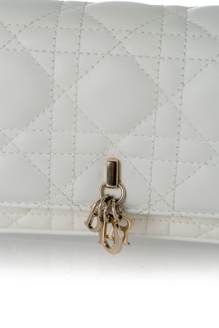 Detalle charms D.I.O.R. dorados sobre Cannage latte Christian Dior