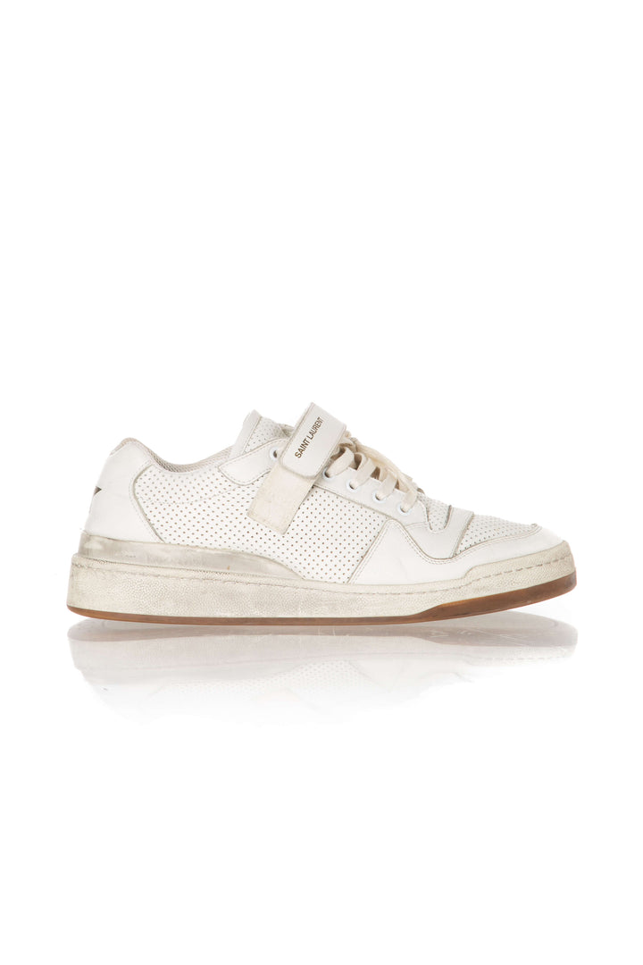 Vista lateral de tenis Saint Laurent en piel perforada marfil con correa velcro