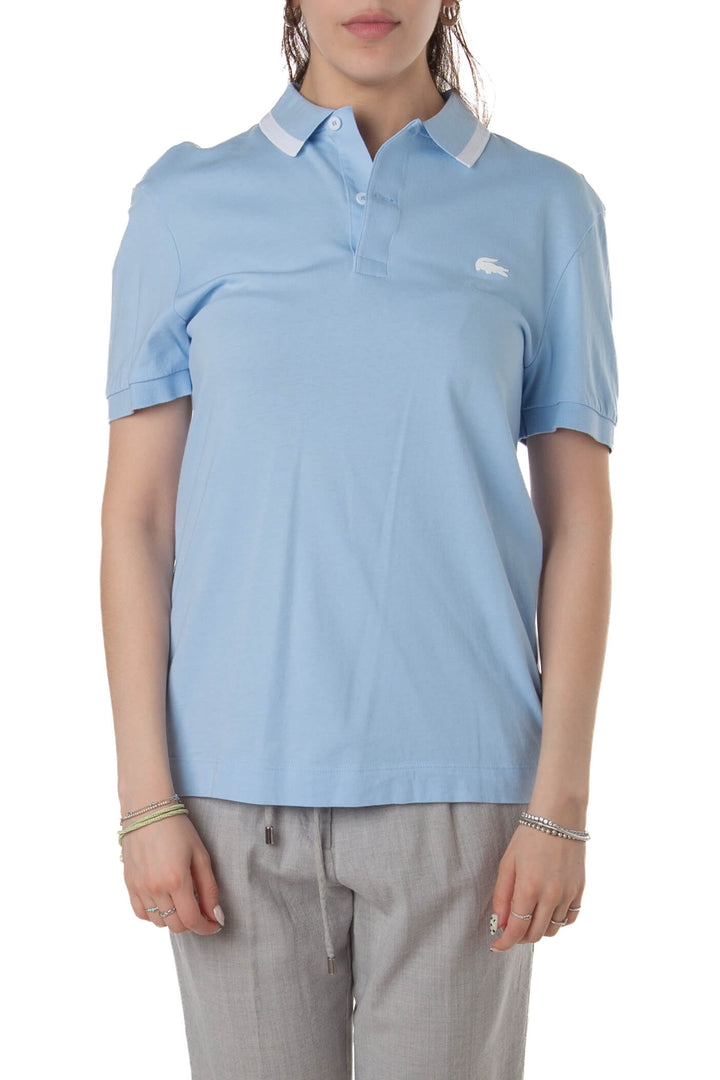 Polo Lacoste azul celeste con logo cocodrilo blanco y franja en el cuello, vista frontal