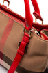 Detalle de hebilla dorada y correa de piel roja Burberry
