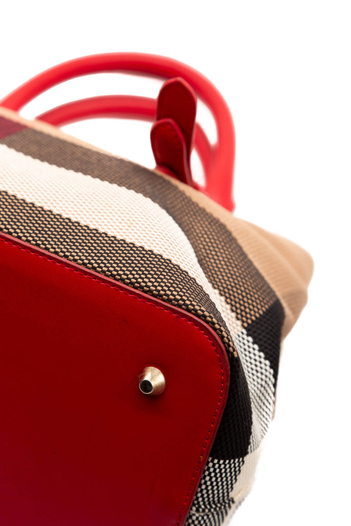 Detalle de esquina de piel roja y lona House Check Burberry
