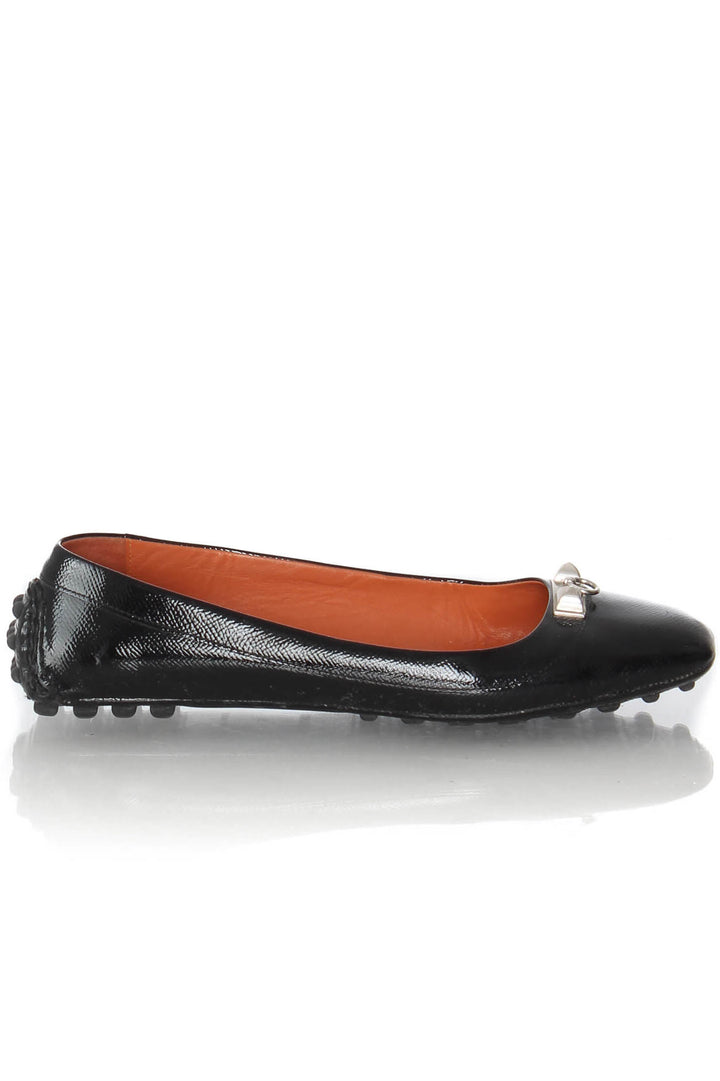 Mocasines Hermès de charol negro con herraje plateado, vista lateral