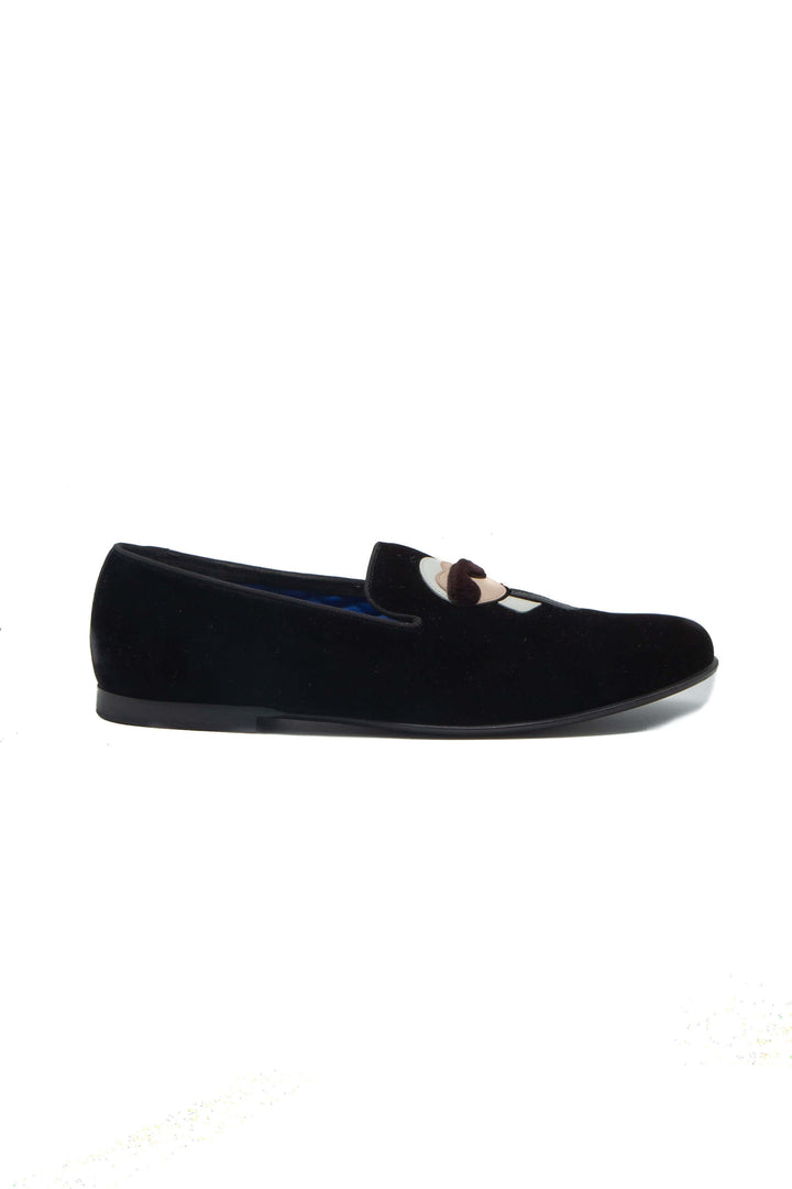 Vista lateral de slipper Fendi en terciopelo negro con aplicación Karlito