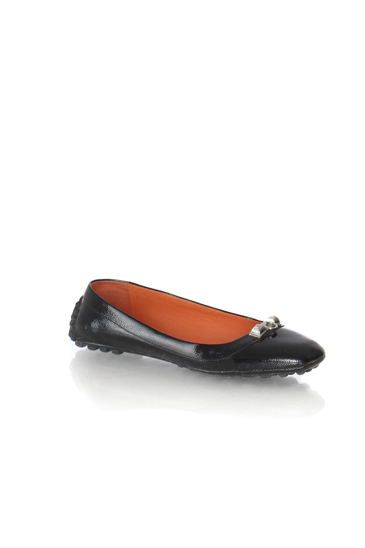 Mocasines Hermès de charol negro con herraje plateado, vista tres cuartos
