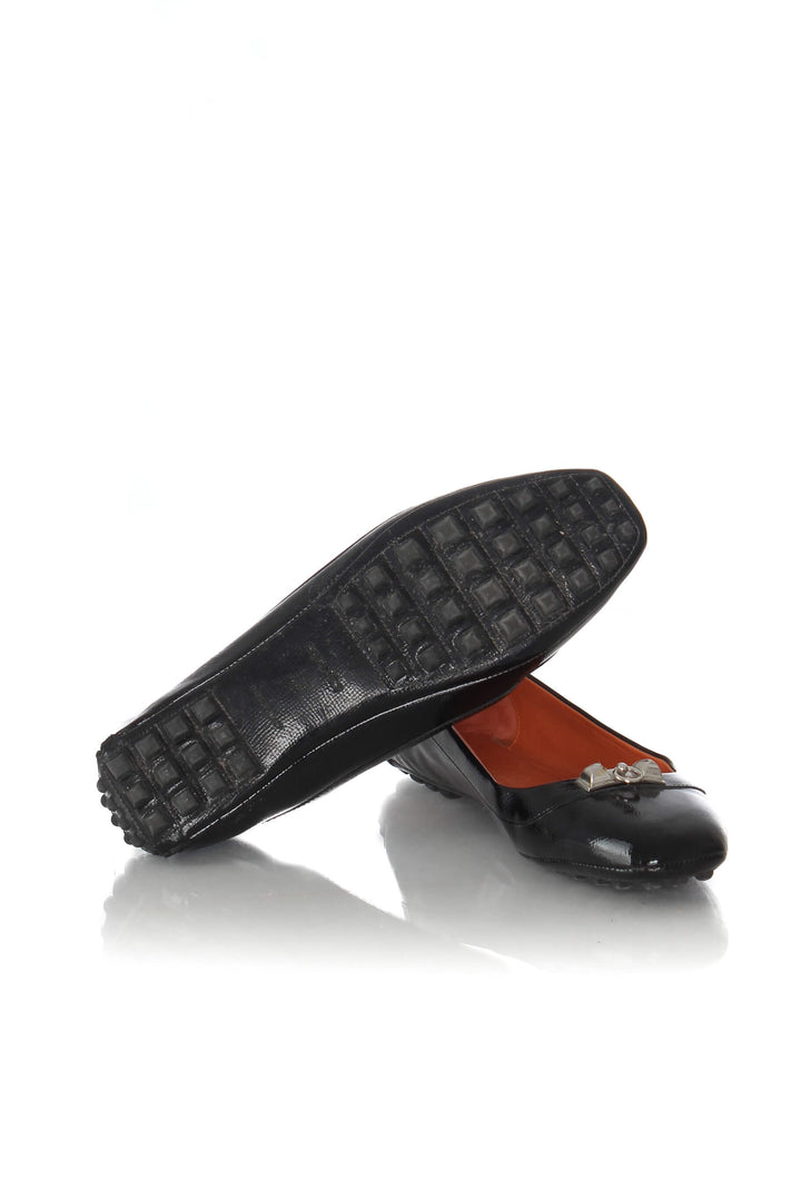 Mocasines Hermès de charol negro con herraje plateado, par mostrando suela de botones