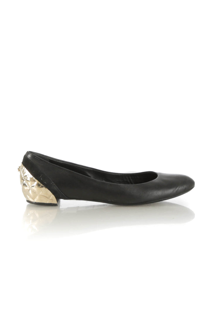 Flats Chanel de piel negra con tacón metálico dorado acolchado, vista lateral