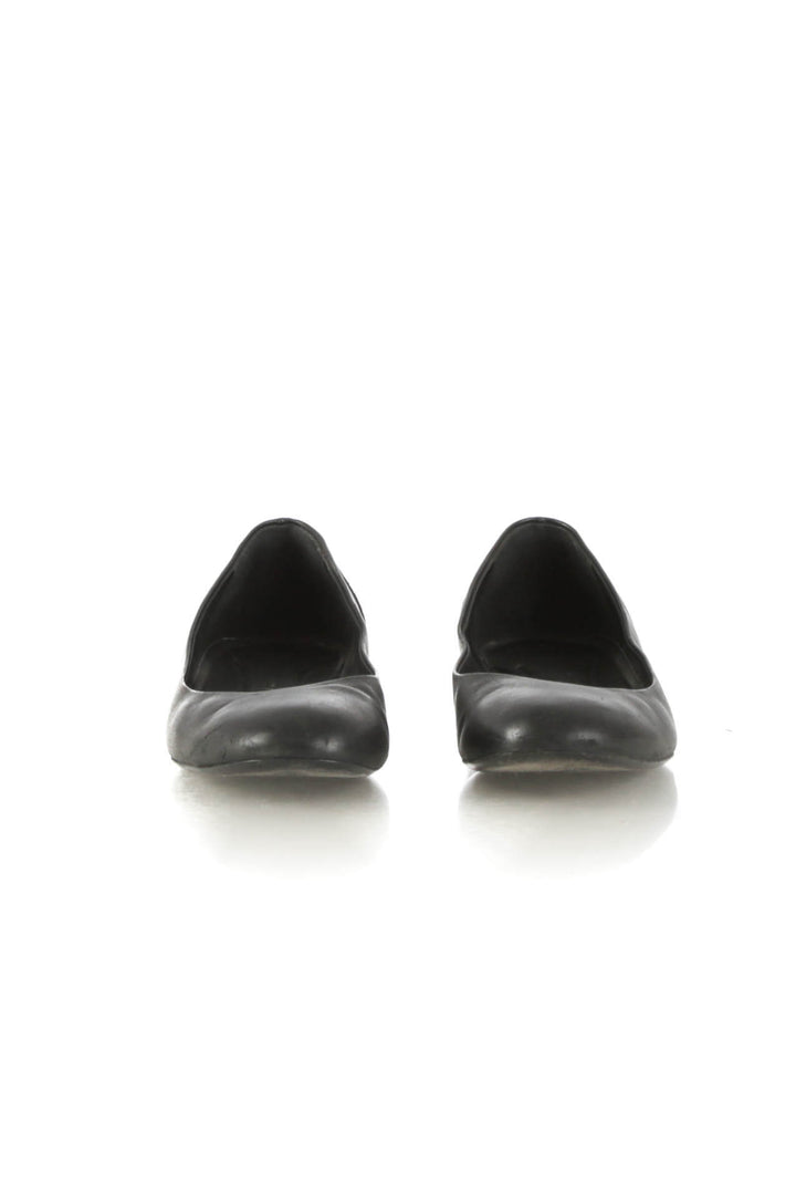 Flats Chanel de piel negra con tacón metálico dorado acolchado, vista frontal del par